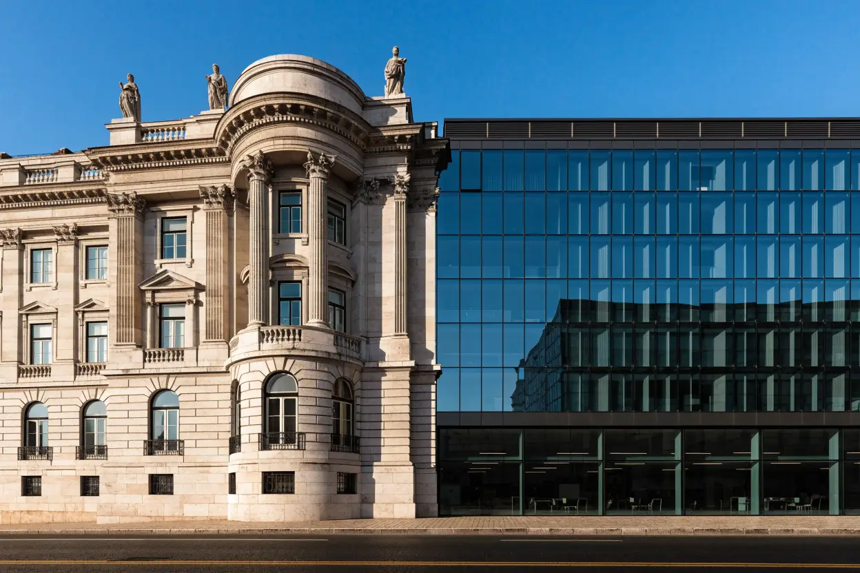 Edifício institucional clássico ao lado de um edifício de escritórios em vidro
